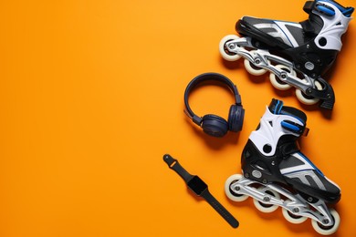 Photo of Flat lay composition with roller skates on orange background. Space for text
