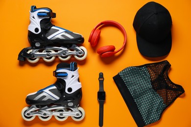 Photo of Flat lay composition with roller skates on orange background