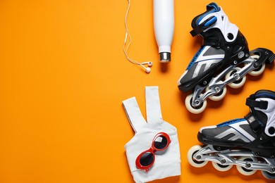 Photo of Flat lay composition with roller skates on orange background. Space for text