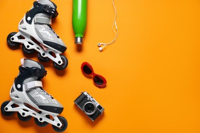 Photo of Flat lay composition with roller skates on orange background. Space for text