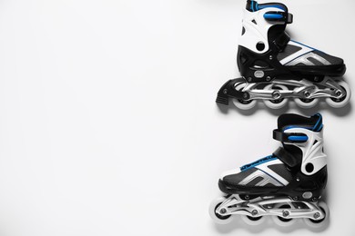 Photo of Pair of roller skates on white background, top view