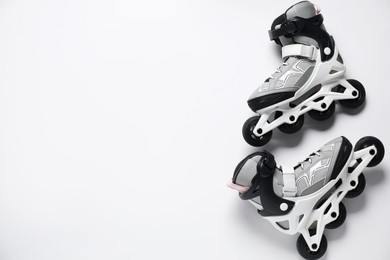 Photo of Pair of roller skates on white background, top view
