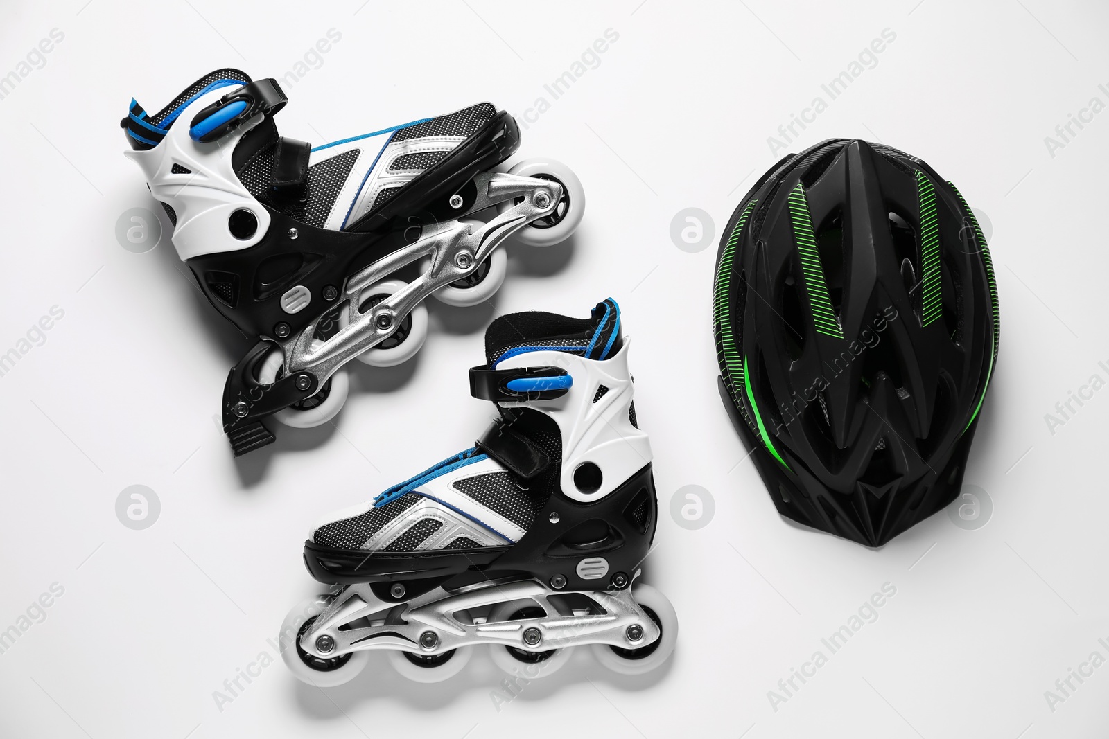 Pair of roller skates and helmet on white background, top view Photo of Pair of roller skates and helmet on white background, top view