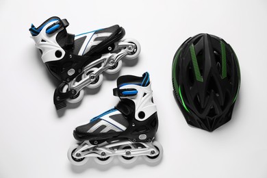 Photo of Pair of roller skates and helmet on white background, top view