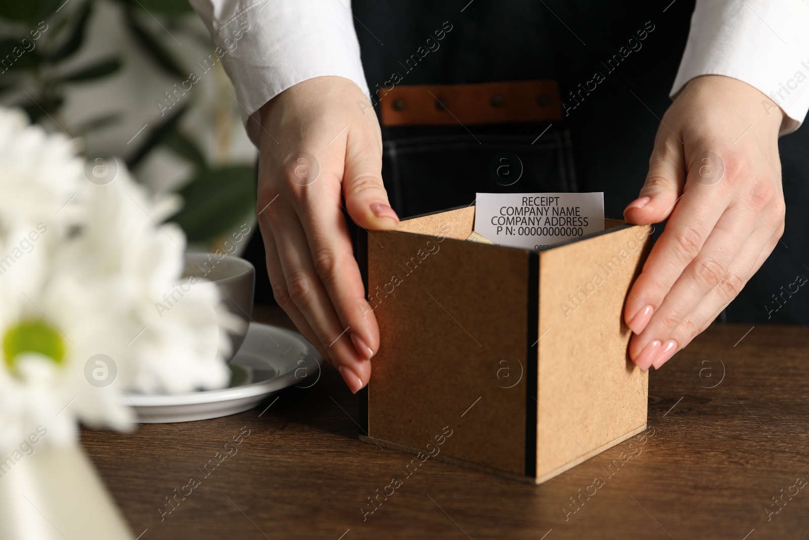 Waitress taking tips from wooden table in cafe, closeup Photo of Waitress taking tips from wooden table in cafe, closeup