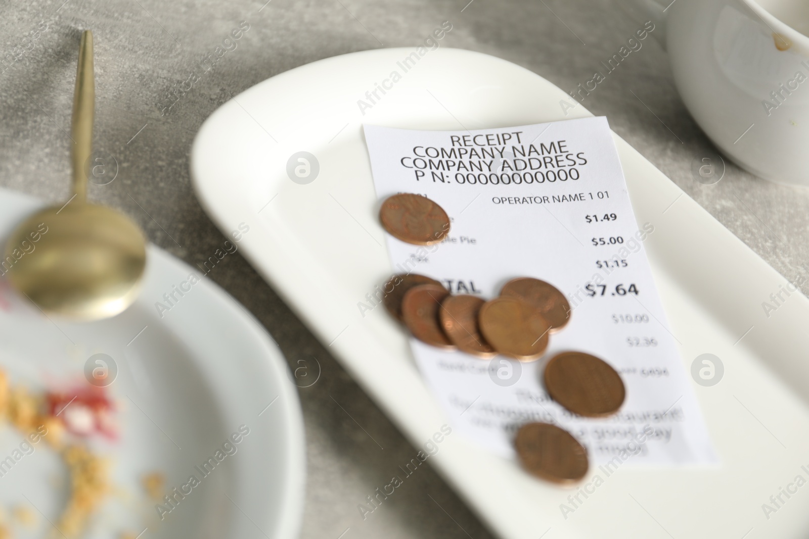 Tips, receipt and dirty plate on grey table, closeup Photo of Tips, receipt and dirty plate on grey table, closeup
