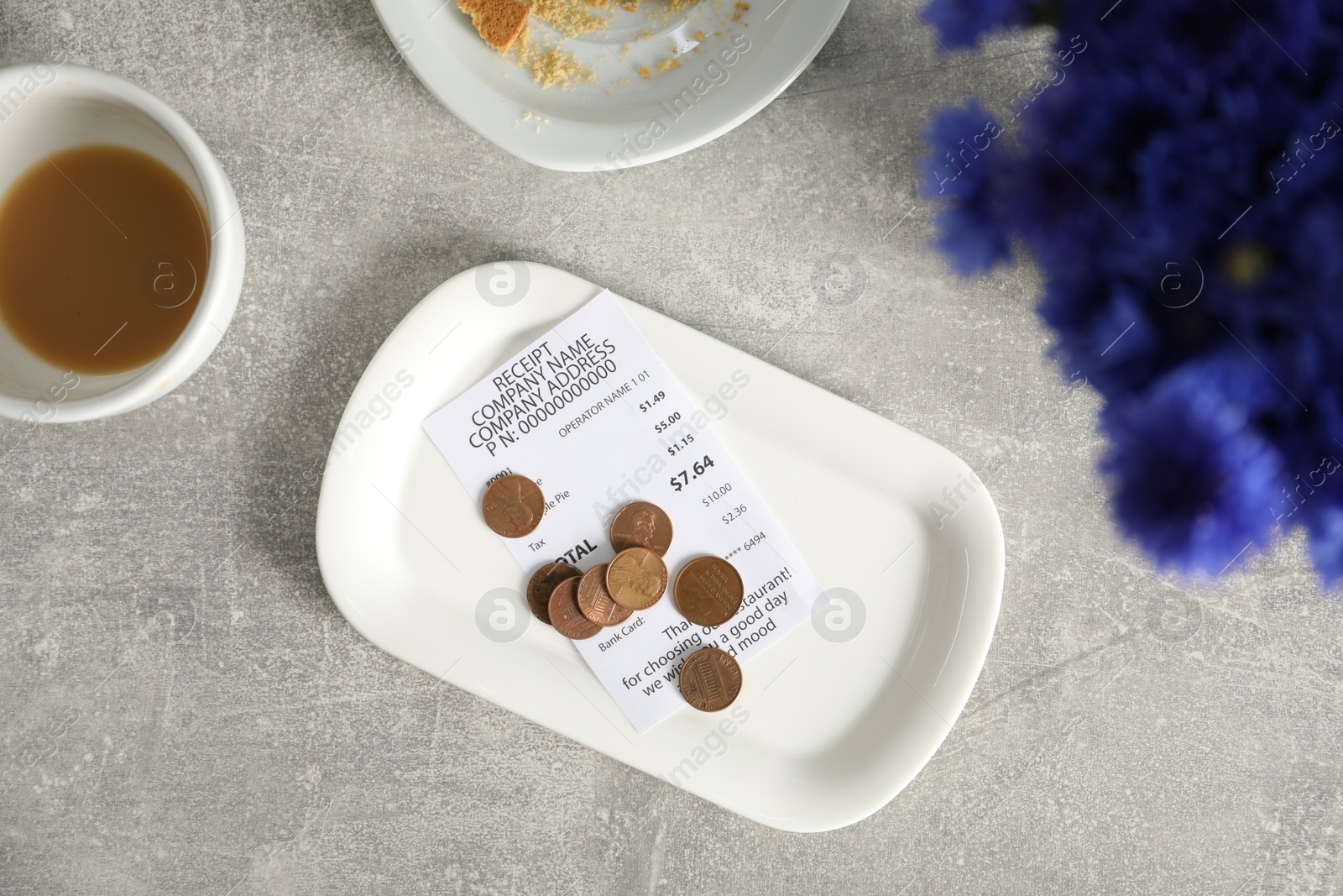 Tips, receipt, dirty plate and cup on grey table, flat lay Photo of Tips, receipt, dirty plate and cup on grey table, flat lay
