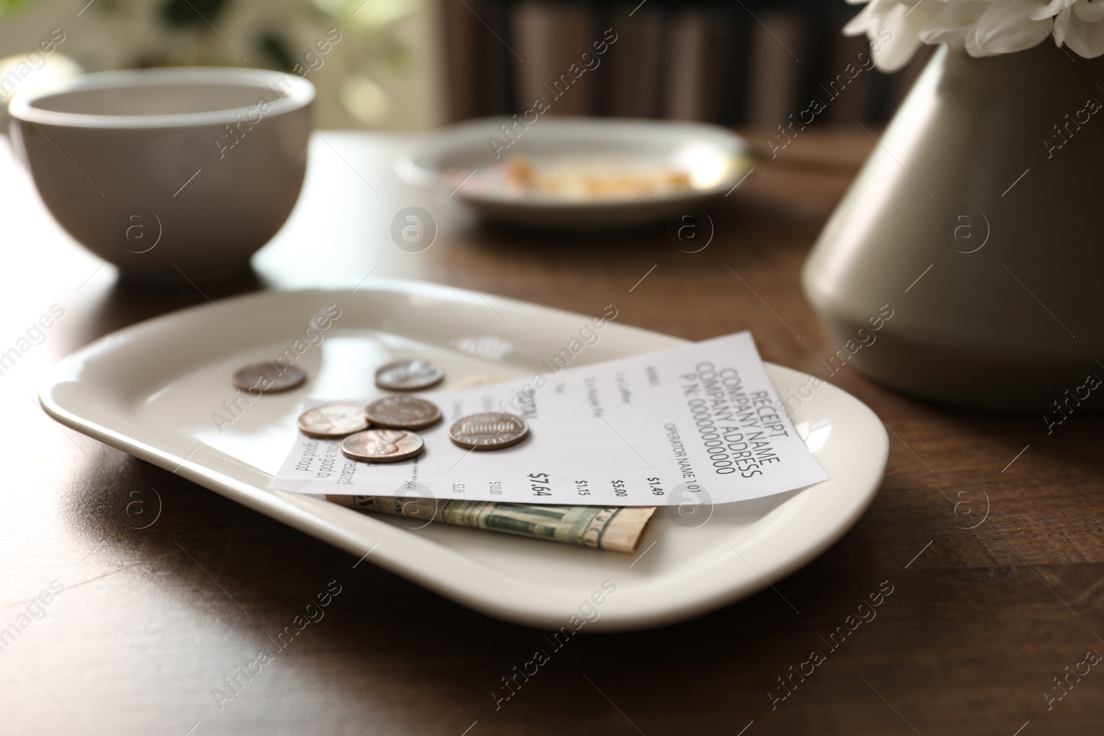 Tips, receipt, dirty plate and cup on wooden table in cafe, closeup Photo of Tips, receipt, dirty plate and cup on wooden table in cafe, closeup