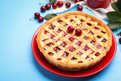 Photo of Tasty cherry pie on light blue wooden table, closeup