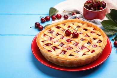 Photo of Tasty cherry pie on light blue wooden table, closeup. Space for text