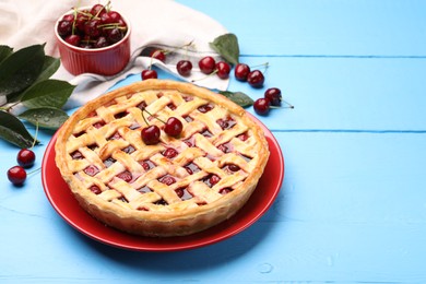 Photo of Tasty cherry pie on light blue wooden table, closeup. Space for text