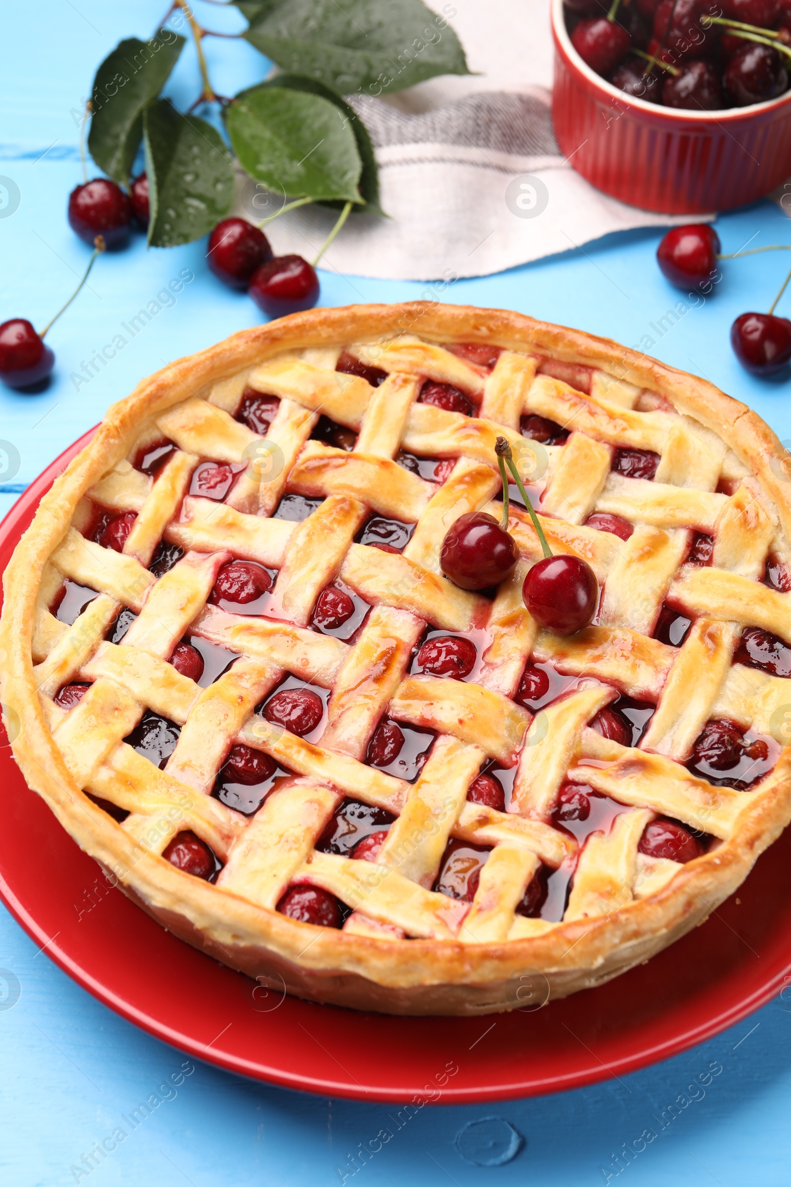 Photo of Tasty cherry pie on light blue wooden table, closeup