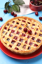 Photo of Tasty cherry pie on light blue wooden table, closeup