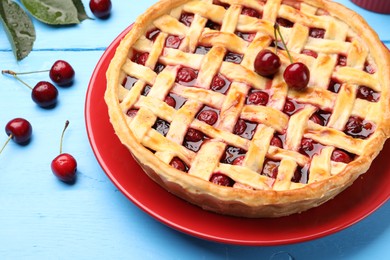 Photo of Tasty cherry pie on light blue wooden table, closeup