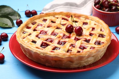 Photo of Tasty cherry pie on light blue wooden table, closeup