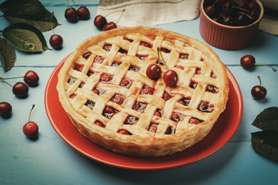 Photo of Tasty cherry pie on light blue wooden table, closeup