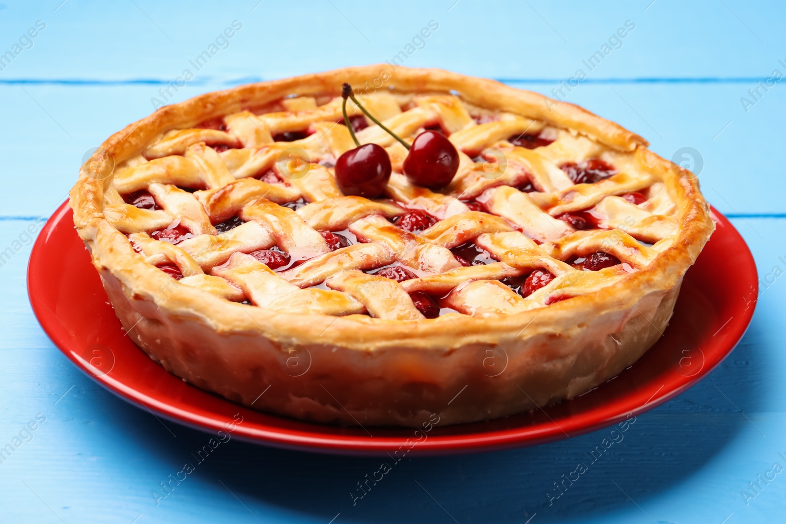 Tasty cherry pie on light blue wooden table, closeup Photo of Tasty cherry pie on light blue wooden table, closeup