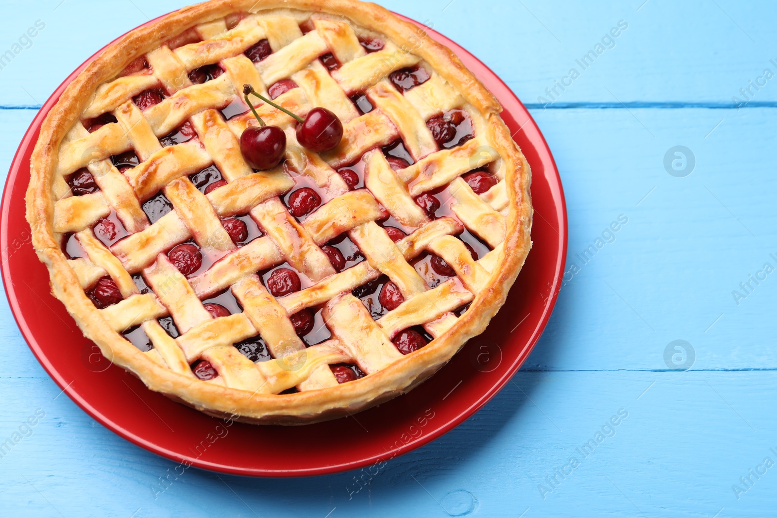 Tasty cherry pie on light blue wooden table, closeup Photo of Tasty cherry pie on light blue wooden table, closeup