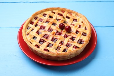 Photo of Tasty cherry pie on light blue wooden table, closeup