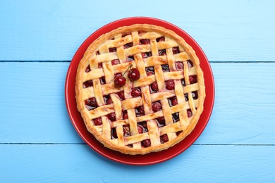 Photo of Tasty cherry pie on light blue wooden table, top view