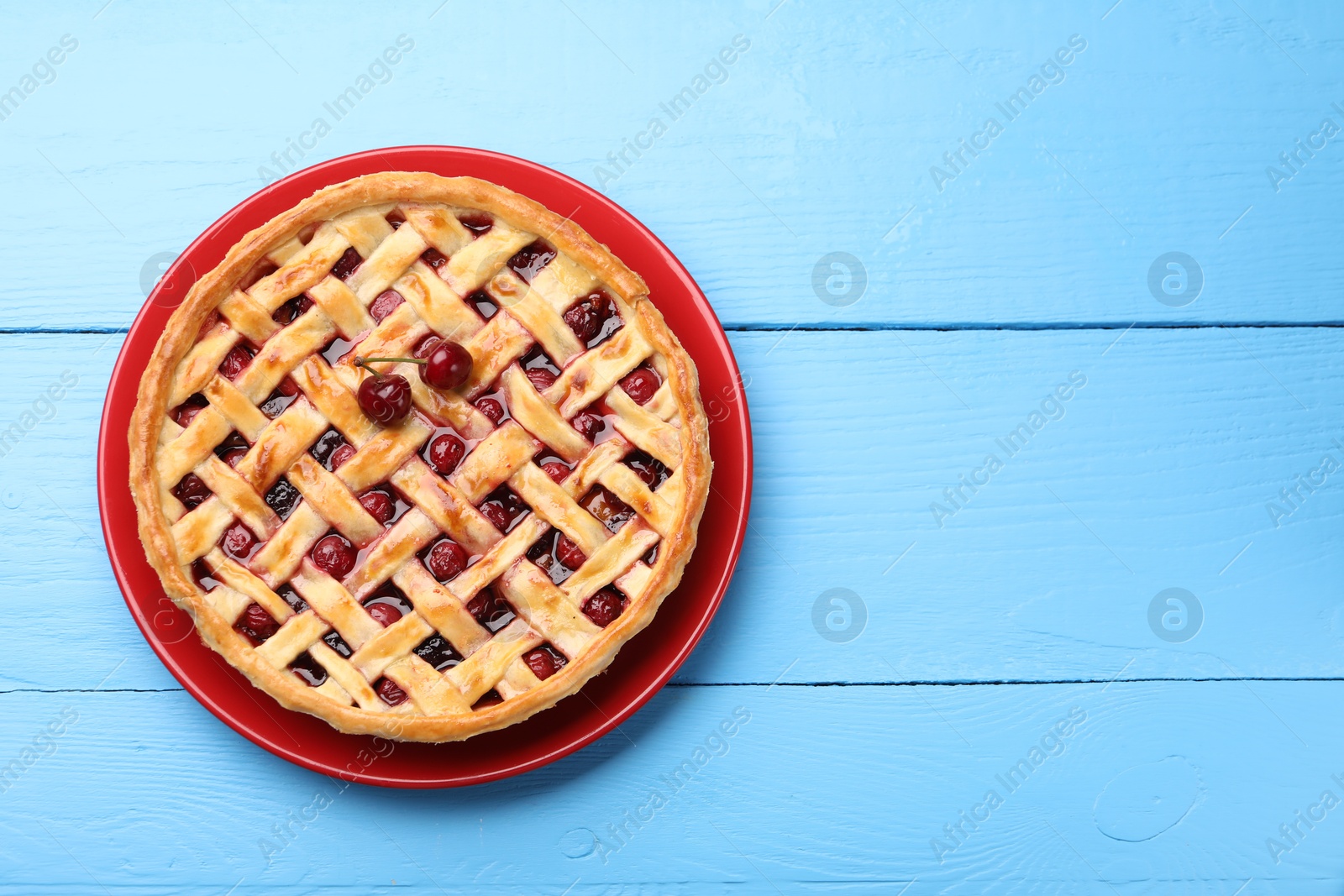 Tasty cherry pie on light blue wooden table, top view. Space for text Photo of Tasty cherry pie on light blue wooden table, top view. Space for text