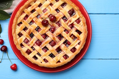 Photo of Tasty cherry pie and berries on light blue wooden table, flat lay