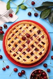 Photo of Tasty cherry pie and berries on light blue wooden table, flat lay