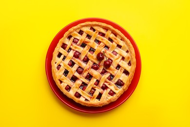 Photo of Tasty cherry pie on yellow background, top view