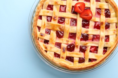 Photo of Tasty strawberry pie on light blue background, top view