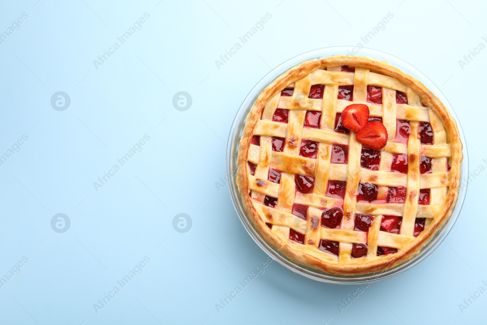 Photo of Tasty strawberry pie on light blue background, top view