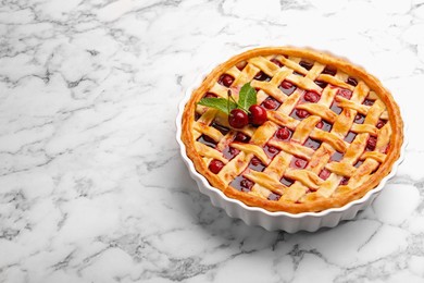 Photo of Tasty cherry pie on white marble table, space for text