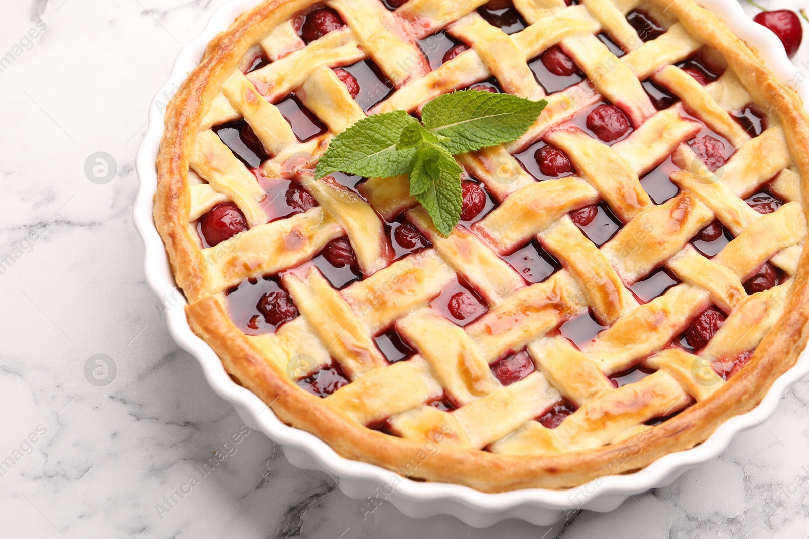 Photo of Tasty cherry pie on white marble table, closeup