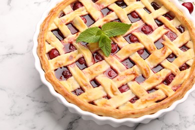 Photo of Tasty cherry pie on white marble table, closeup
