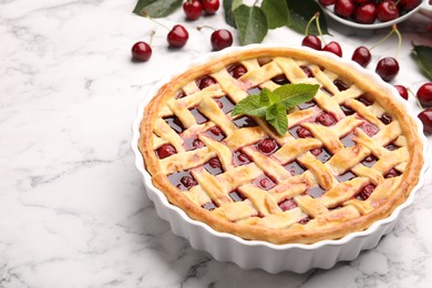 Photo of Tasty cherry pie and berries on white marble table, closeup. Space for text