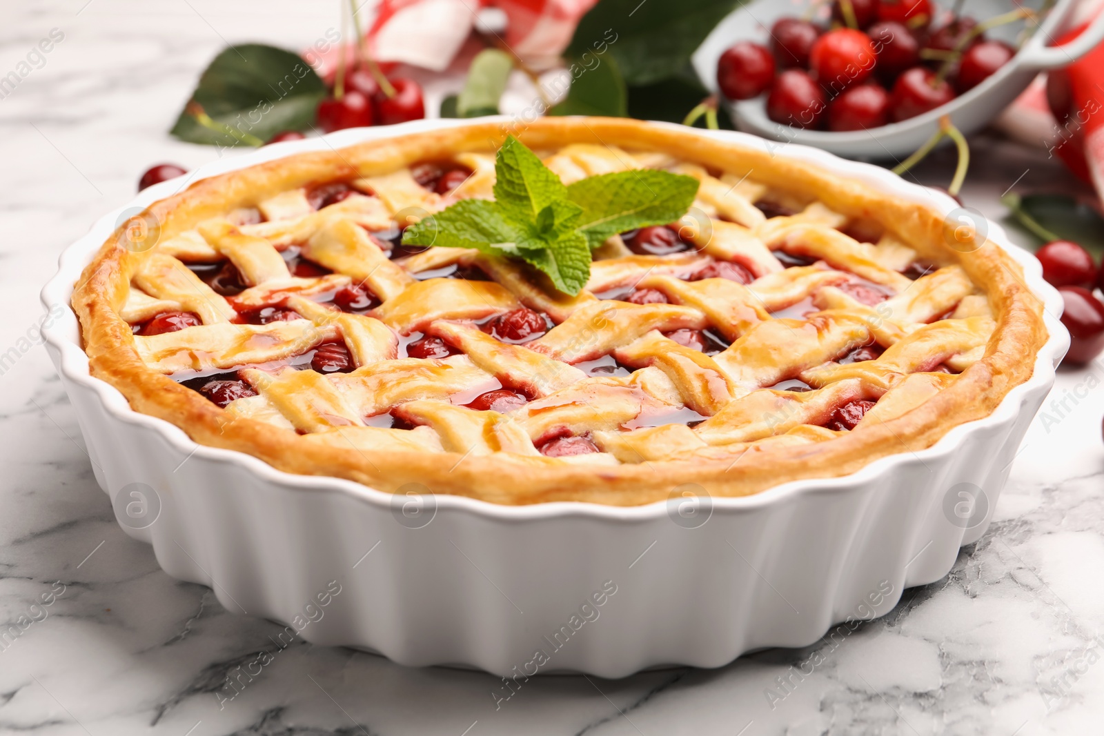 Photo of Tasty cherry pie and berries on white marble table, closeup
