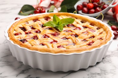 Photo of Tasty cherry pie and berries on white marble table, closeup