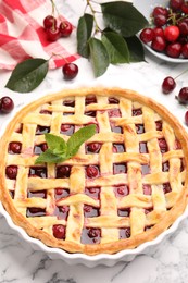 Photo of Tasty cherry pie and berries on white marble table, closeup
