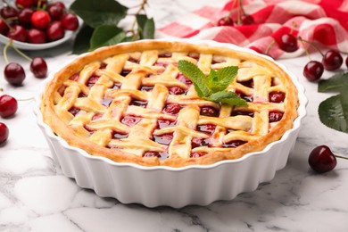 Photo of Tasty cherry pie and berries on white marble table, closeup