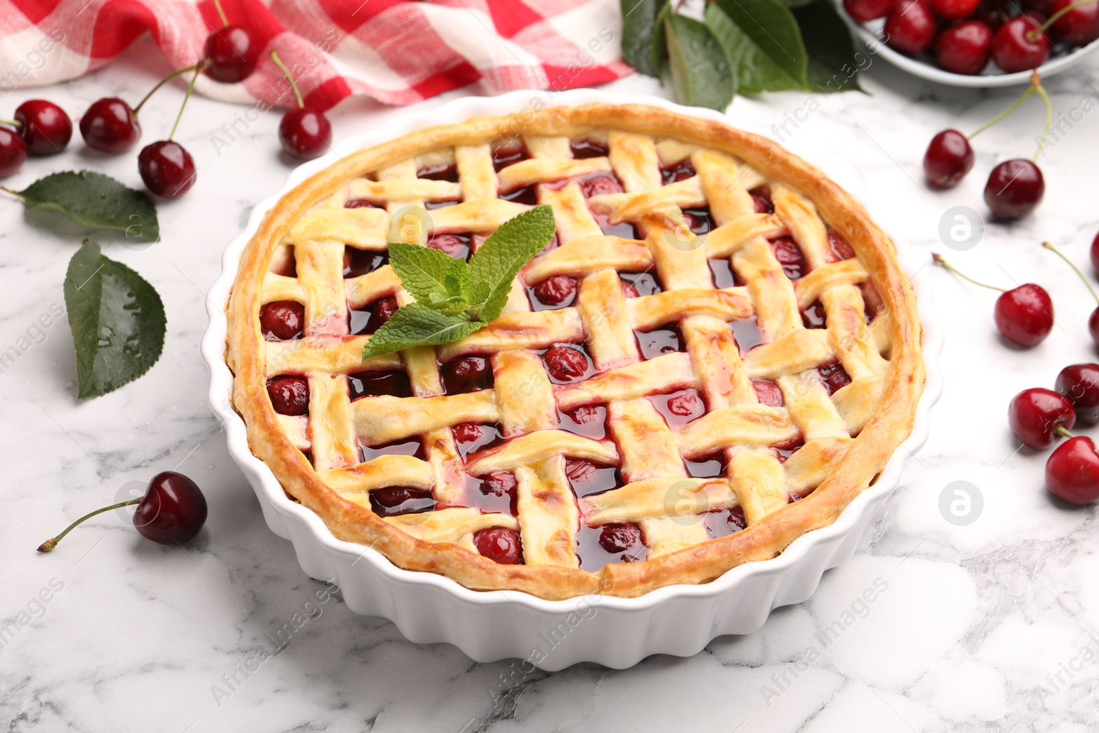 Photo of Tasty cherry pie and berries on white marble table, closeup