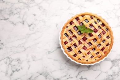 Photo of Tasty cherry pie on white marble table, top view. Space for text