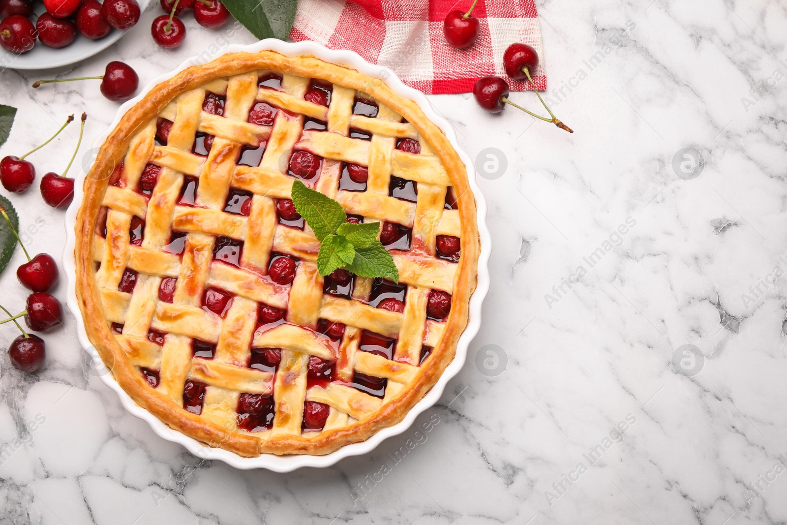Tasty cherry pie and berries on white marble table, flat lay. Space for text Photo of Tasty cherry pie and berries on white marble table, flat lay. Space for text