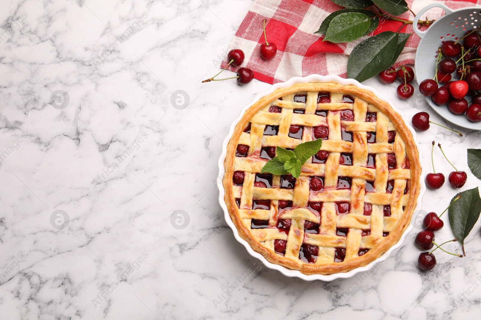 Photo of Tasty cherry pie and berries on white marble table, flat lay. Space for text