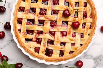 Photo of Tasty cherry pie and berries on white marble table, flat lay