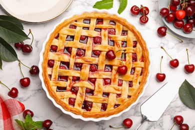 Photo of Tasty cherry pie and berries on white marble table, flat lay