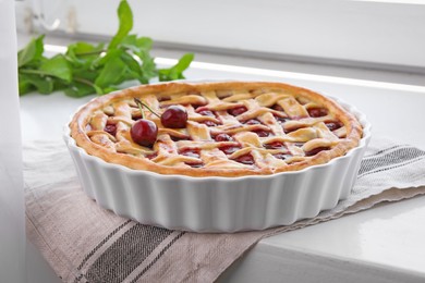 Photo of Tasty cherry pie on windowsill indoors, closeup