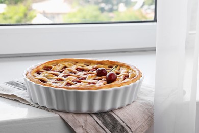 Photo of Tasty cherry pie on windowsill indoors, closeup