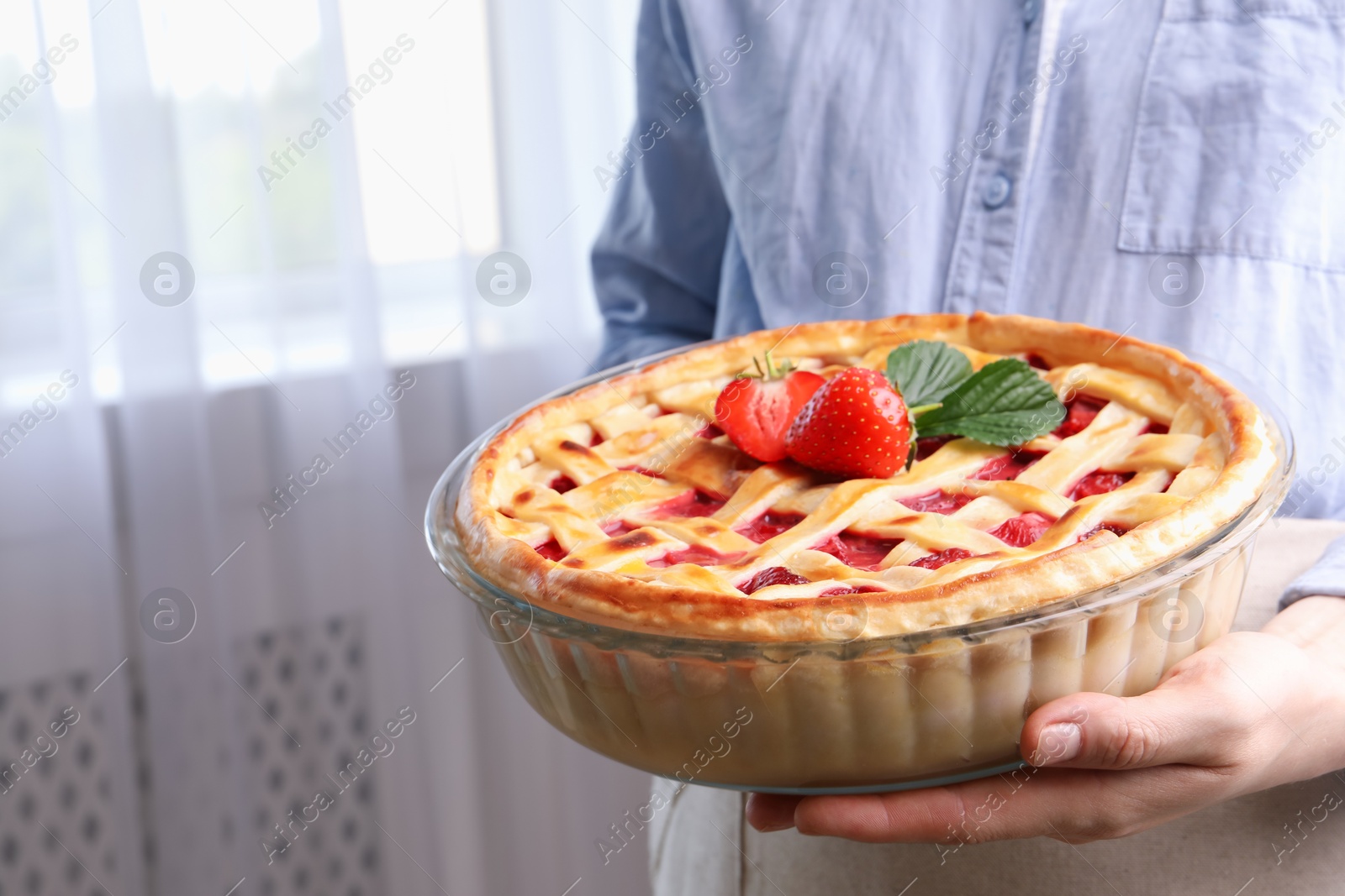 Woman holding tasty strawberry pie indoors, closeup Photo of Woman holding tasty strawberry pie indoors, closeup