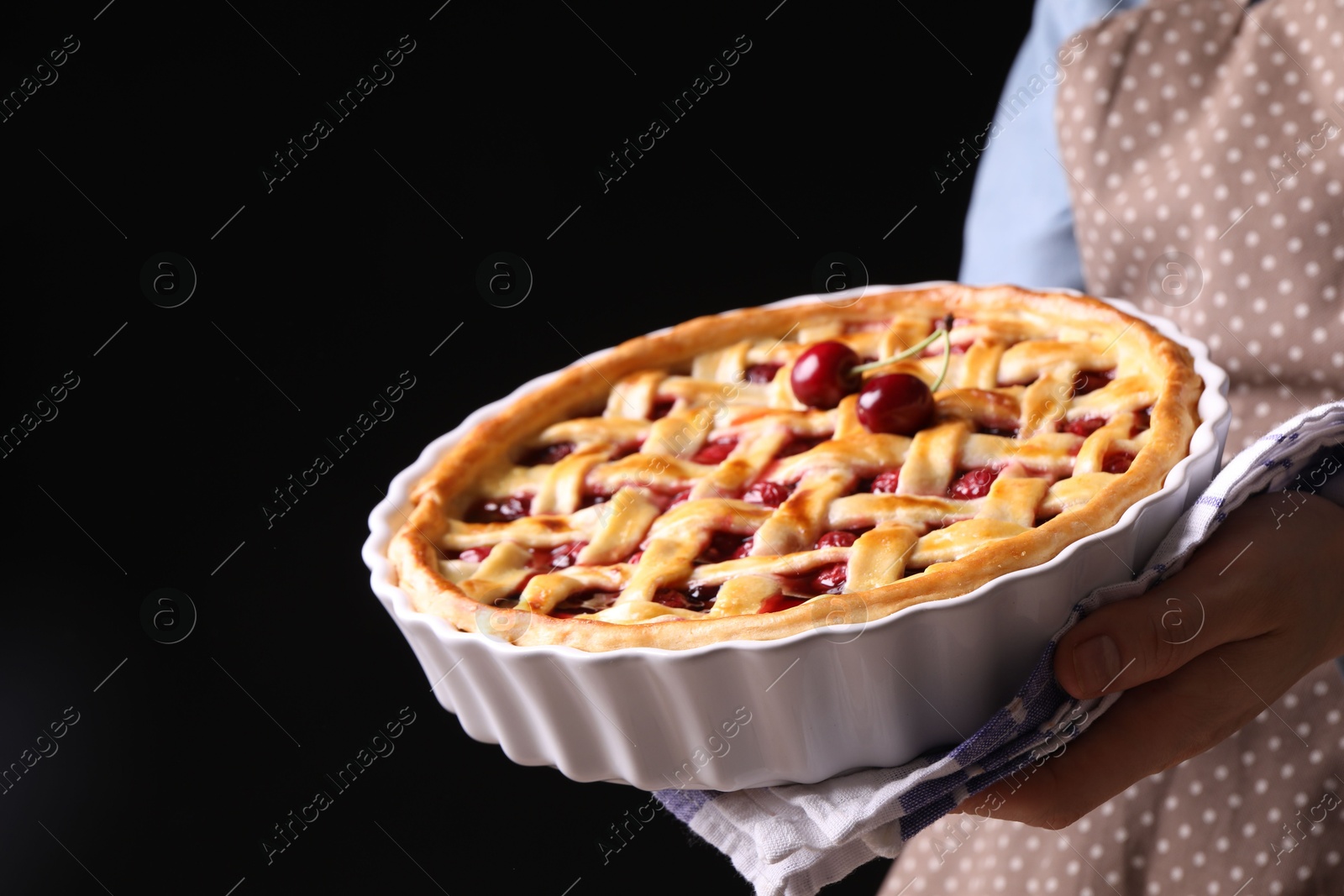 Woman holding tasty cherry pie on black background, closeup Photo of Woman holding tasty cherry pie on black background, closeup