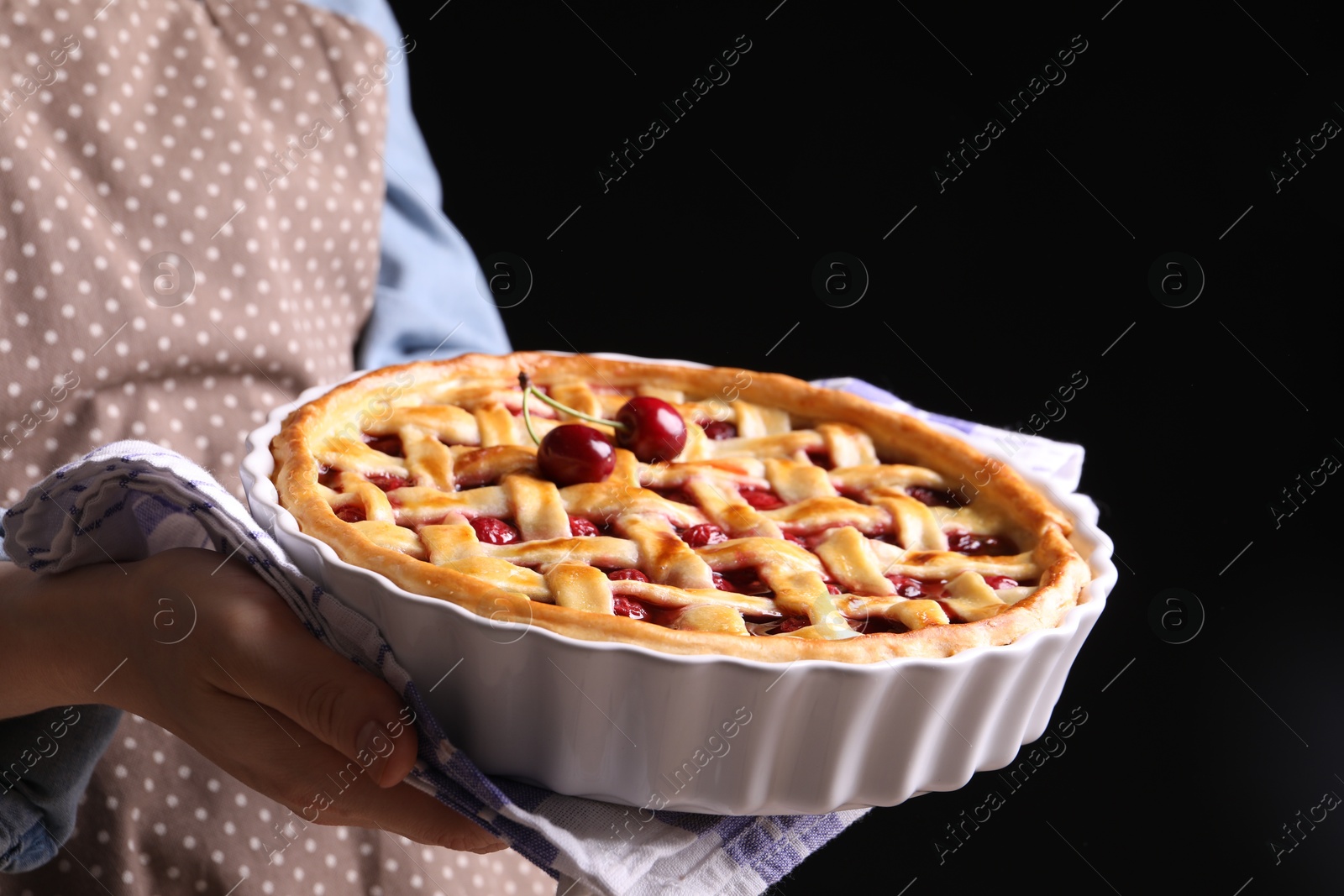 Woman holding tasty cherry pie on black background, closeup Photo of Woman holding tasty cherry pie on black background, closeup