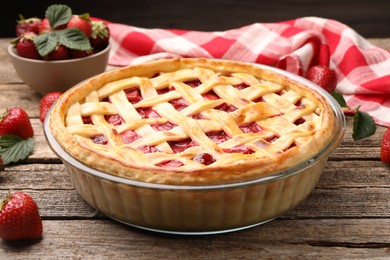 Photo of Tasty strawberry pie and berries on wooden table, closeup